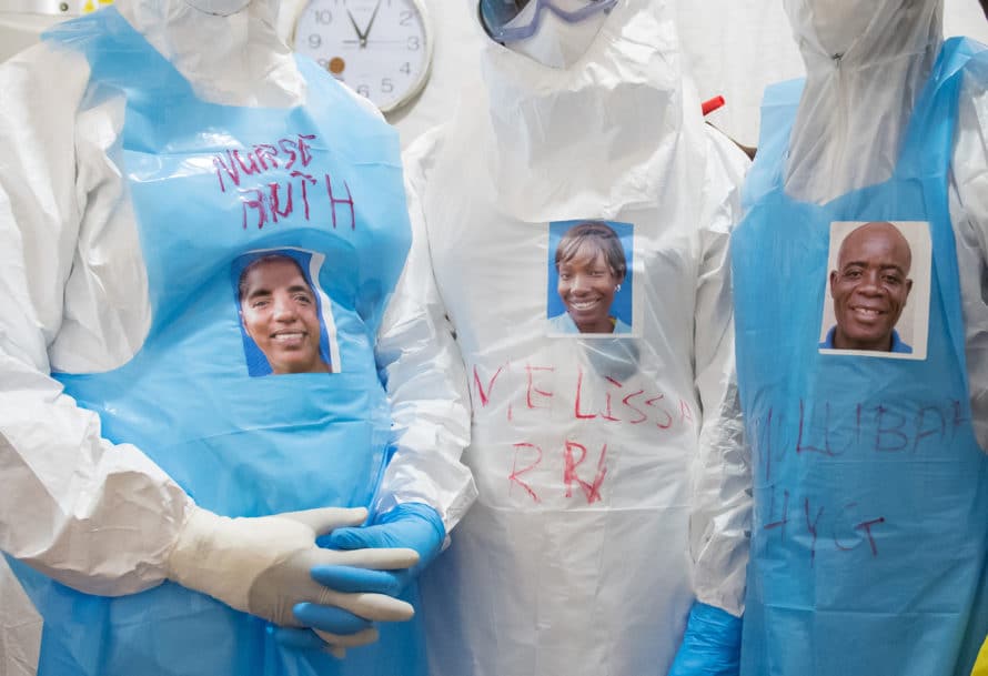 Wearing stickers with their faces on them, health care workers prepare to enter the “red zone” to care for unconfirmed Ebola patients in the ELWA II ETU (Ebola treatment unit), Monrovia, Liberia on Friday, March 6, 2015. Occidental College professor Mary Beth Heffernan’s PPE Portrait Project involves creating wearable portraits of the health care workers who must wear PPE (personal protective equipment) when working with patients. Photo by Marc Campos, Occidental College Photographer