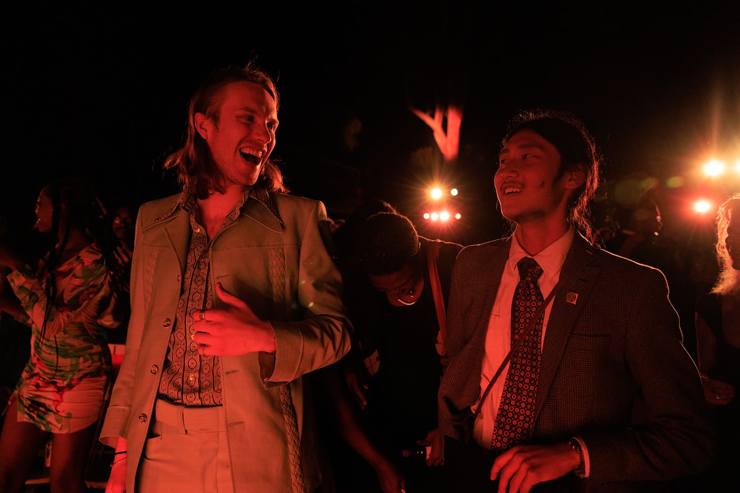 Candid of two students talking happily outside on graduation night.