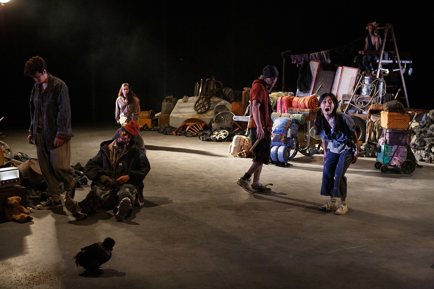 A group of people on stage, one sitting while others stand