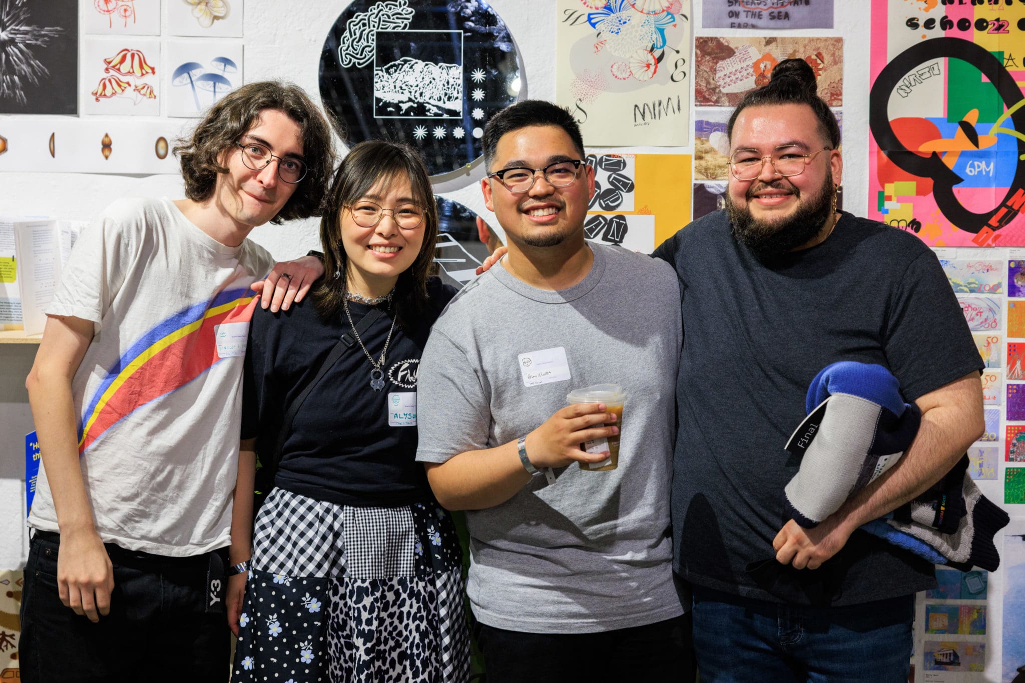 4 friends with arms around each other smiling