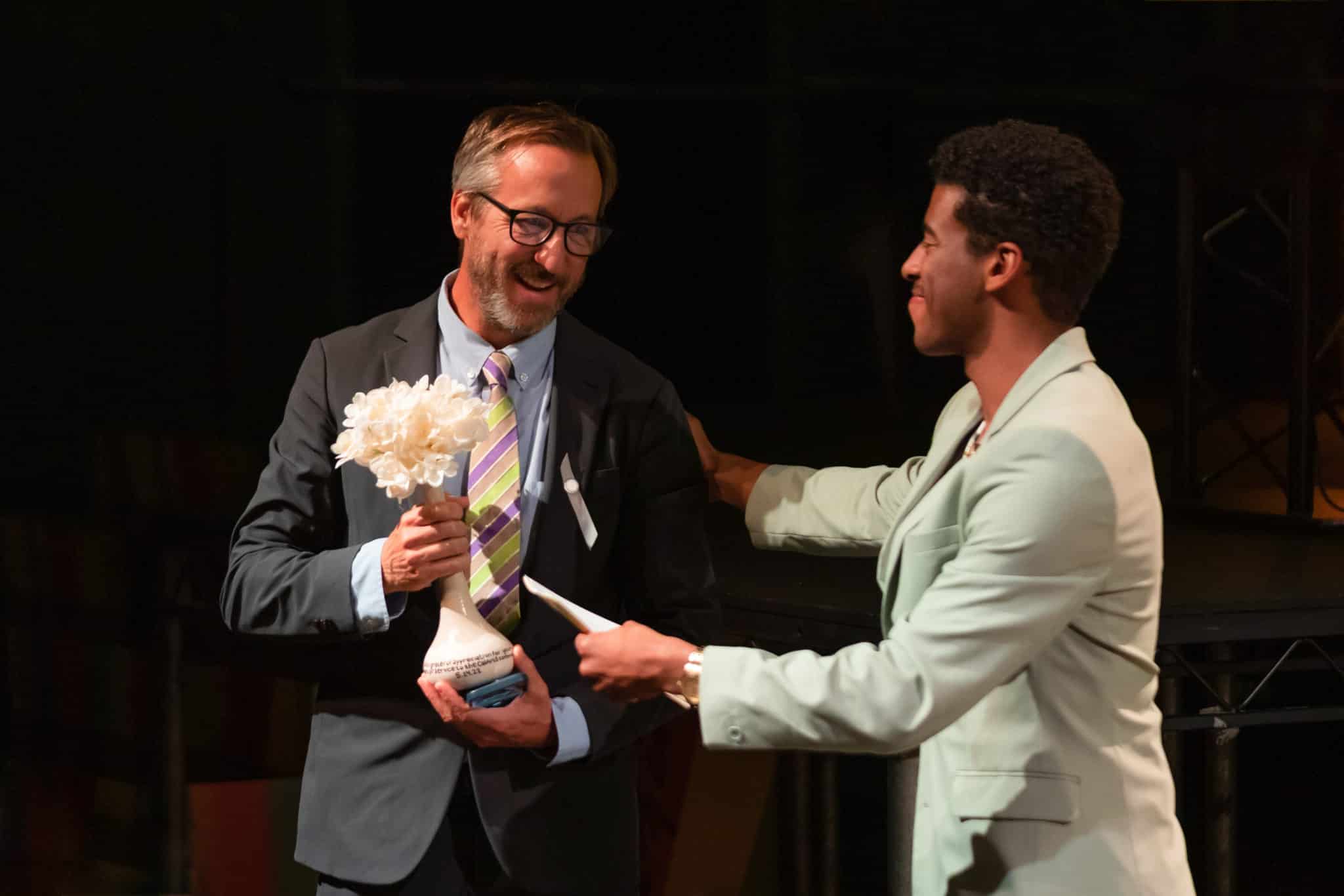 man receives an award from the host of the event