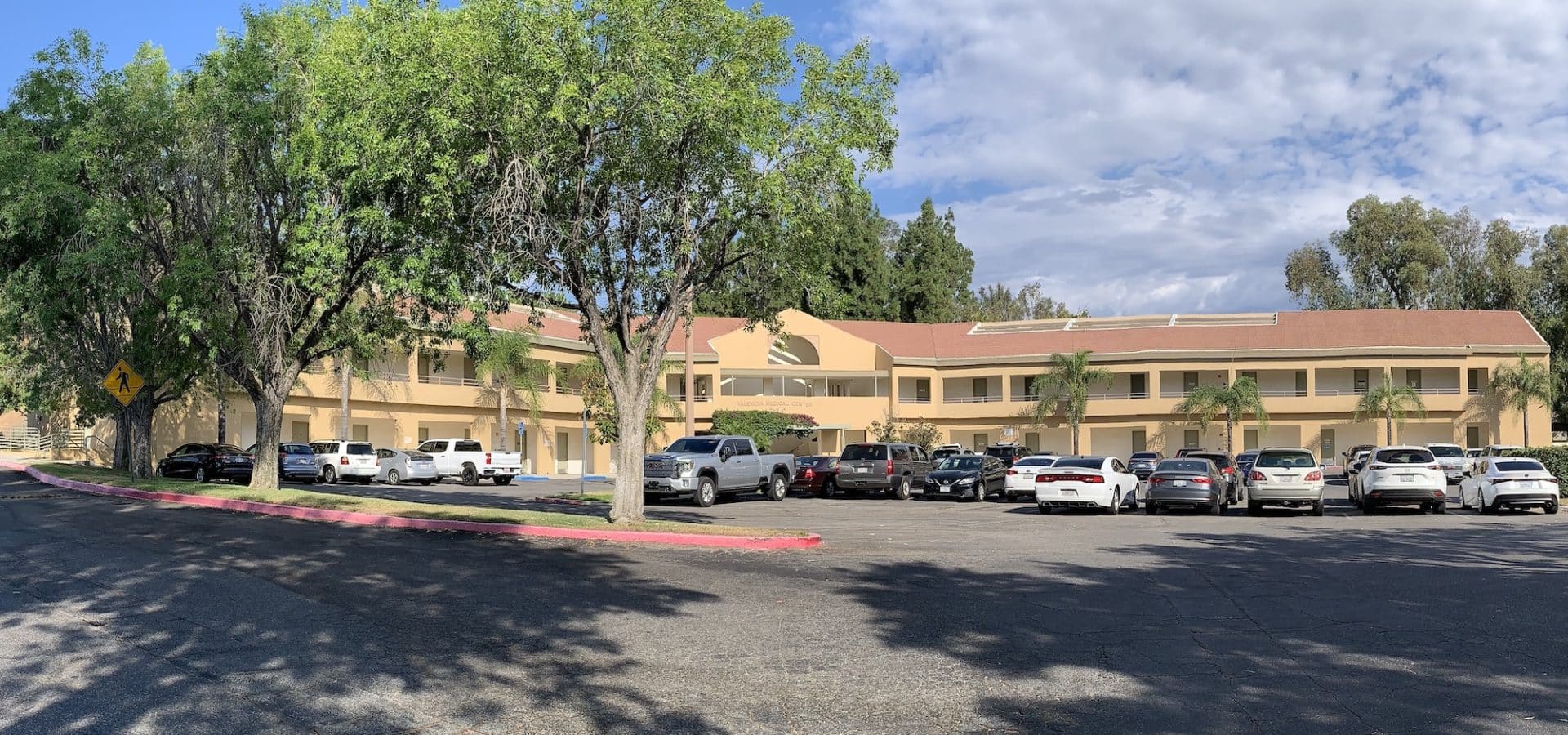 A tan building in the middle of a parking lot