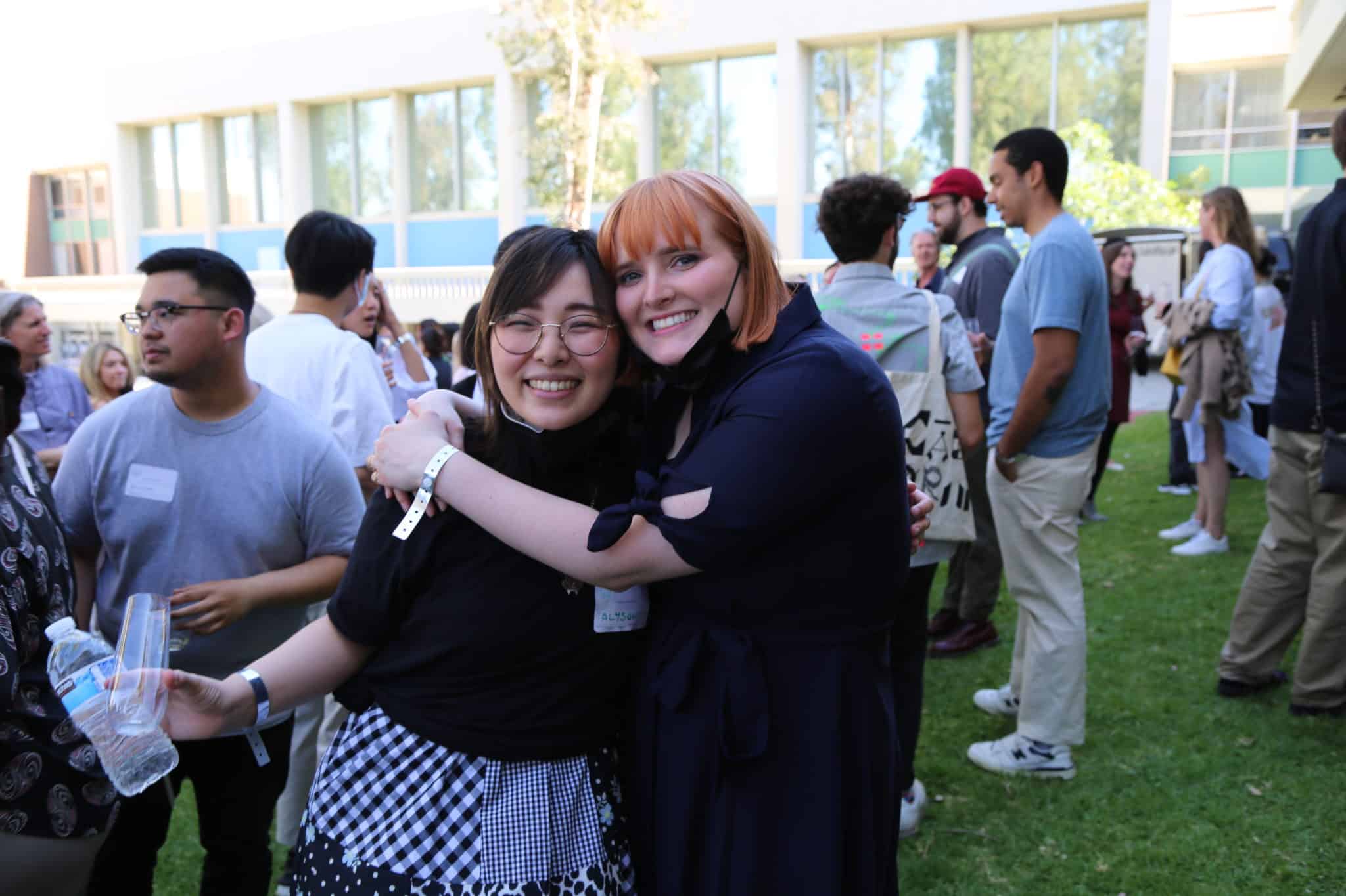 Two people hug in the middle of a crowd