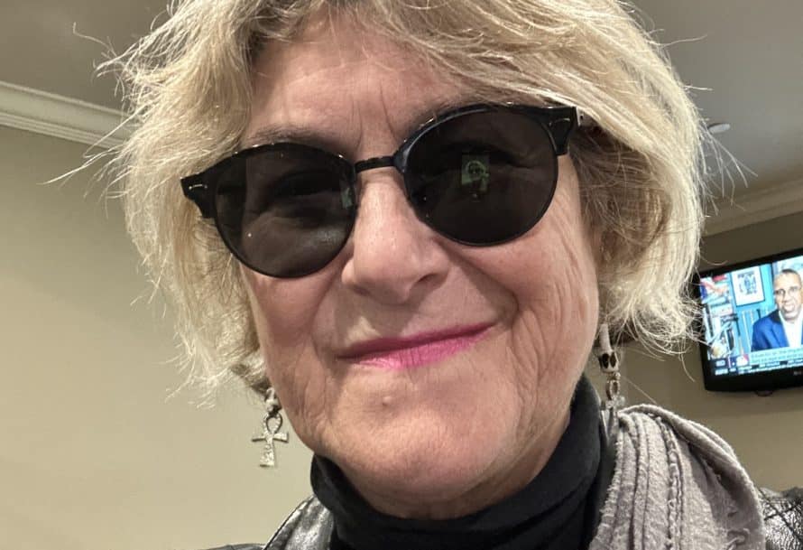 Headshot of a person in sunglasses indoors.